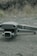 A drone labeled 'Mavic 2' with a Hasselblad camera rests on a textured asphalt surface. The background features blurred grass and rocks.