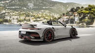 a white sports car parked in front of a lake