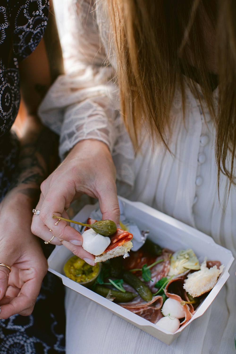 a close up of a person holding a box of food