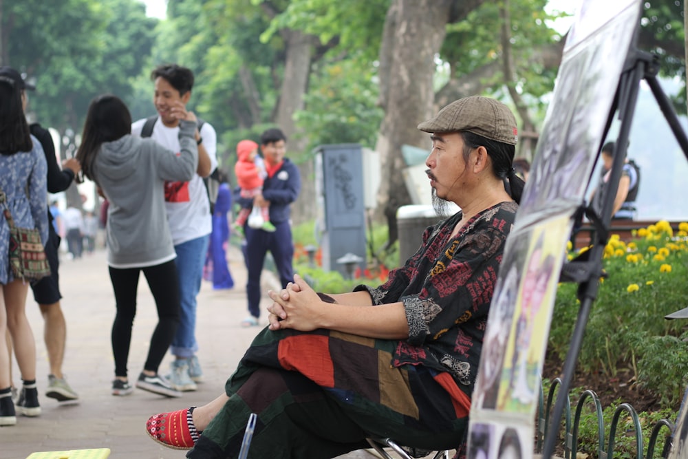 a man sitting on a bench in front of a group of people