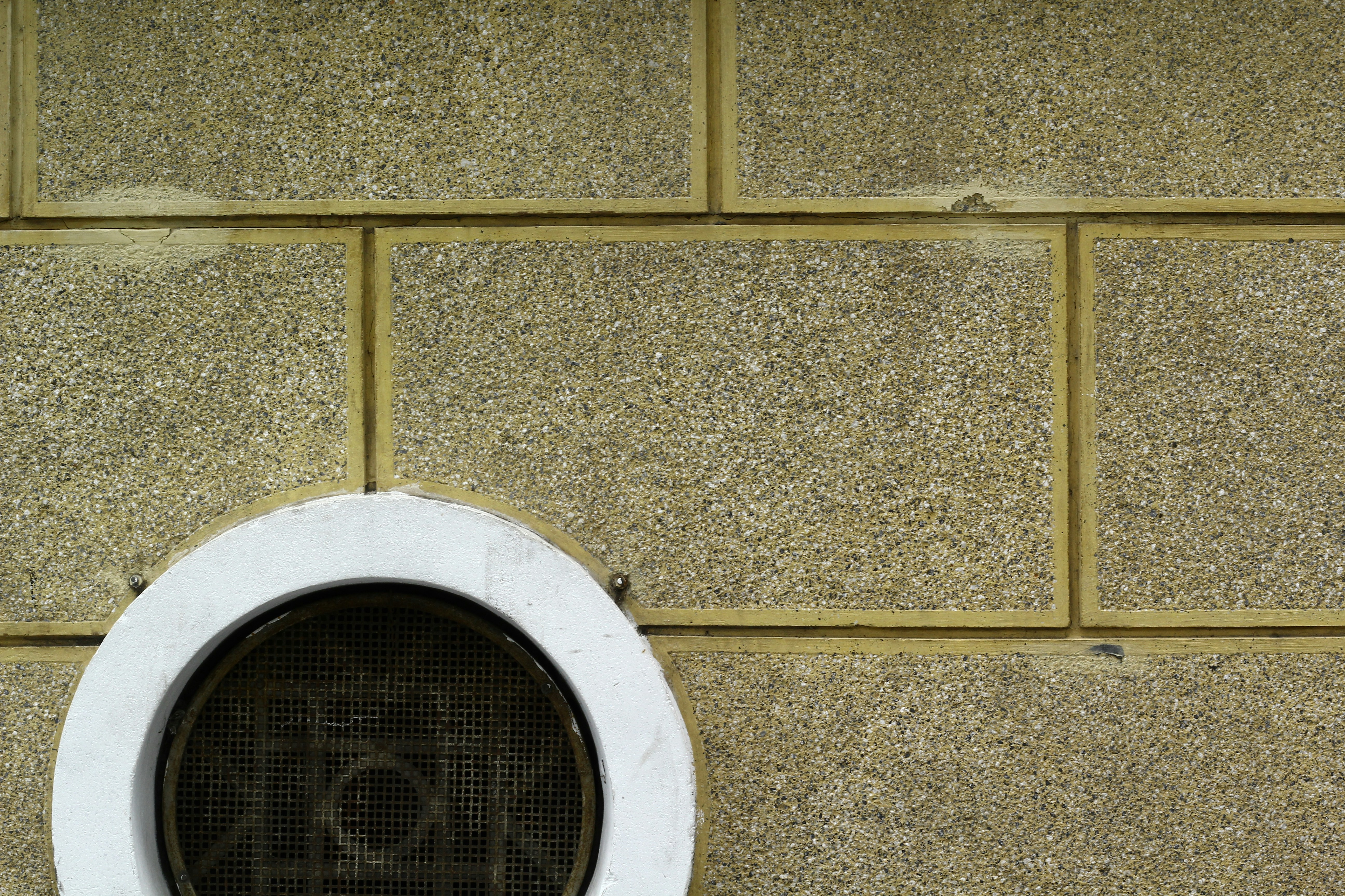 a round window on the side of a brick wall