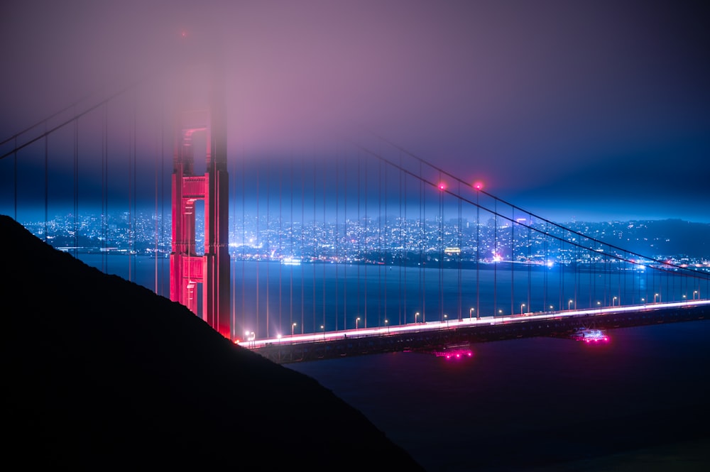 the golden gate bridge is lit up at night