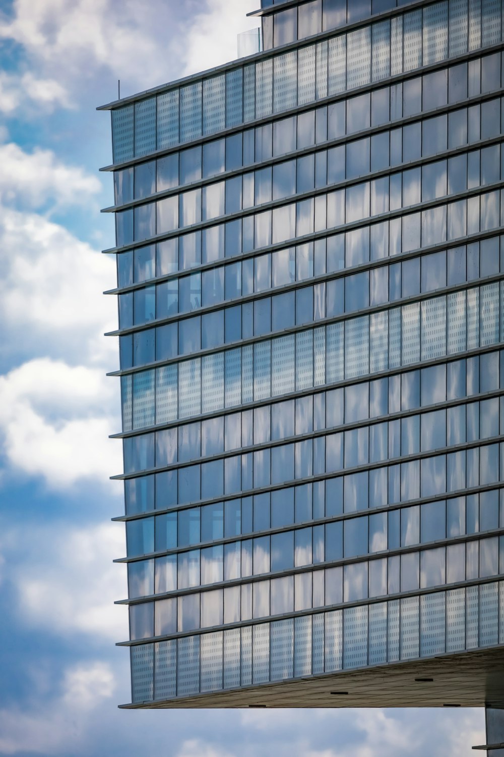 a tall building with many windows and a sky background