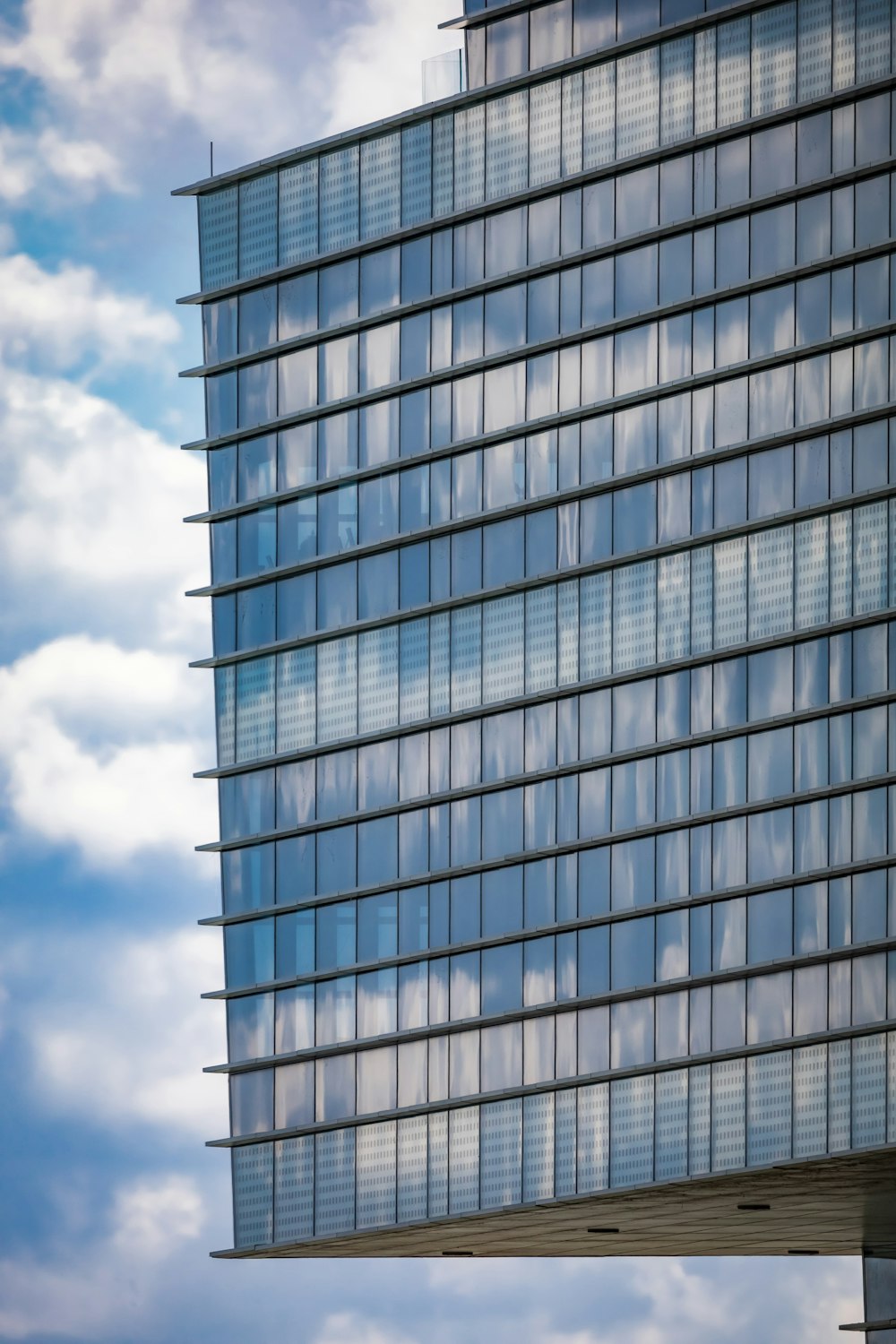 Un edificio alto con molte finestre e uno sfondo del cielo