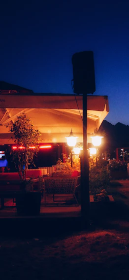 A cozy villa terrace at sunset with warm lights and comfortable seating.
