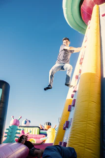 a man is jumping over a bouncy castle