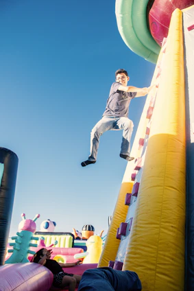 a man is jumping over a bouncy castle