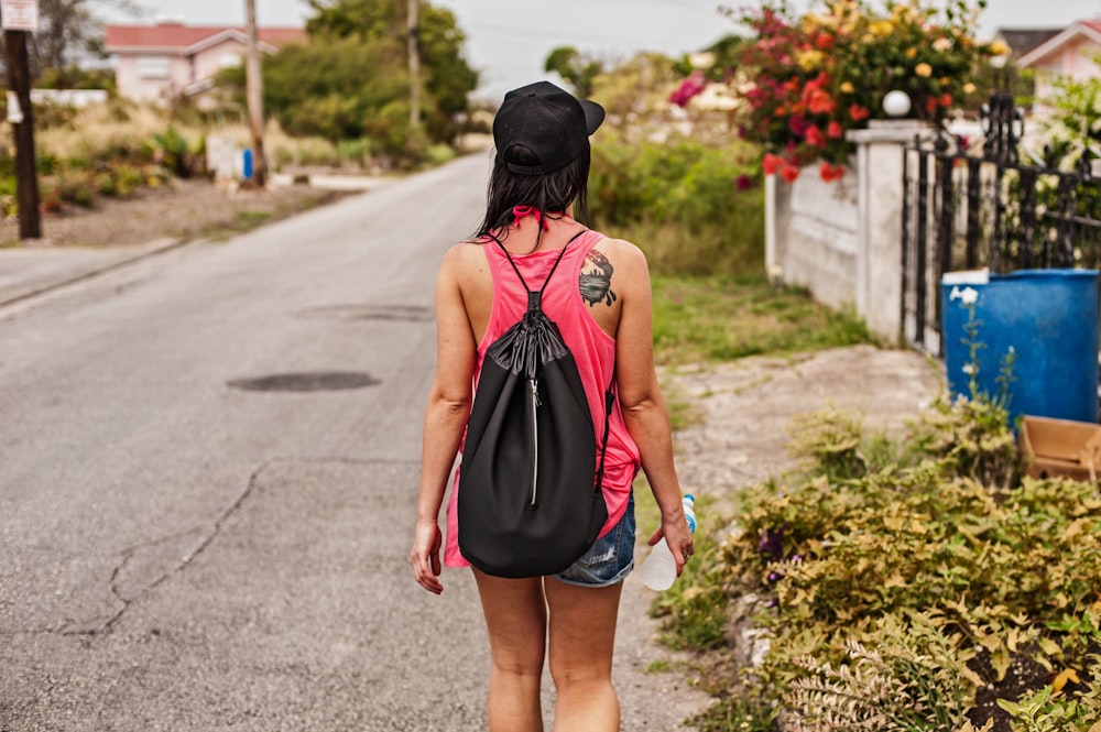 a woman walking down the street carrying a black bag