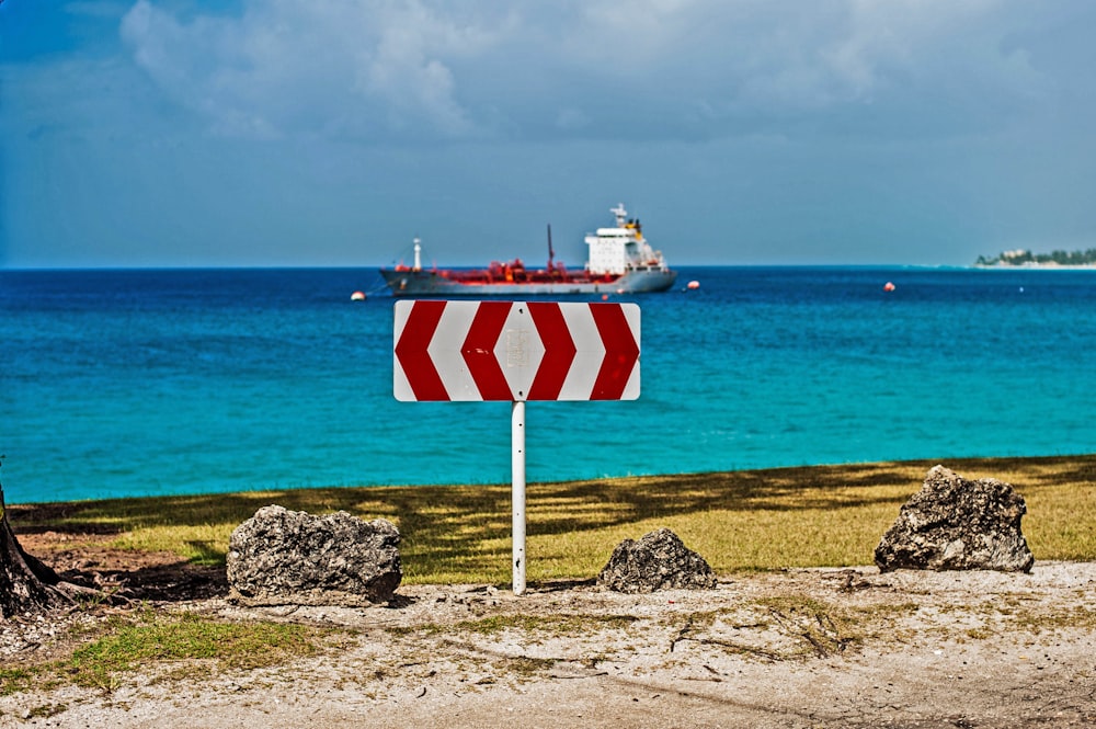 a red and white sign sitting on the side of a road