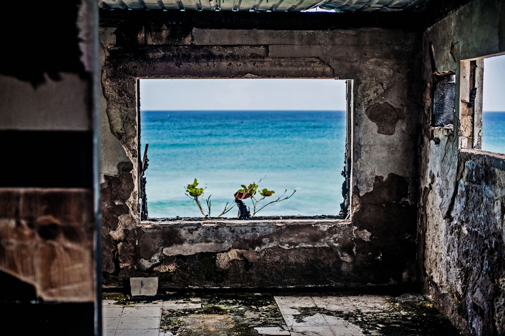 a view of the ocean through a broken window