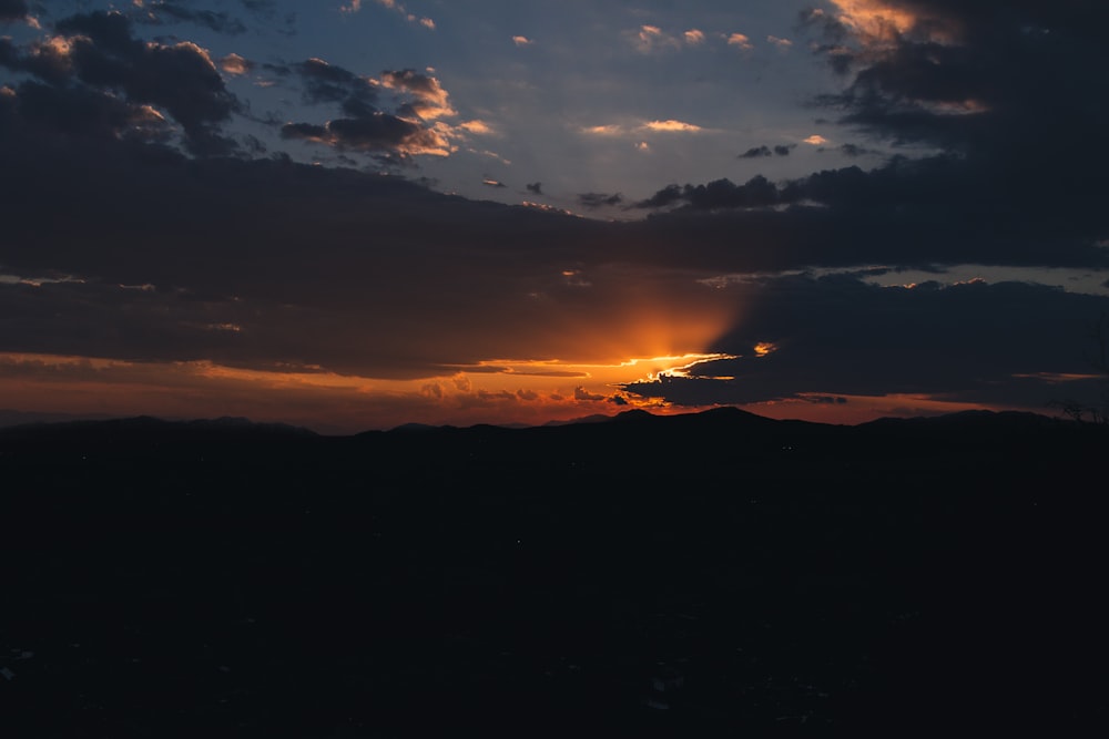 the sun is setting over a mountain range