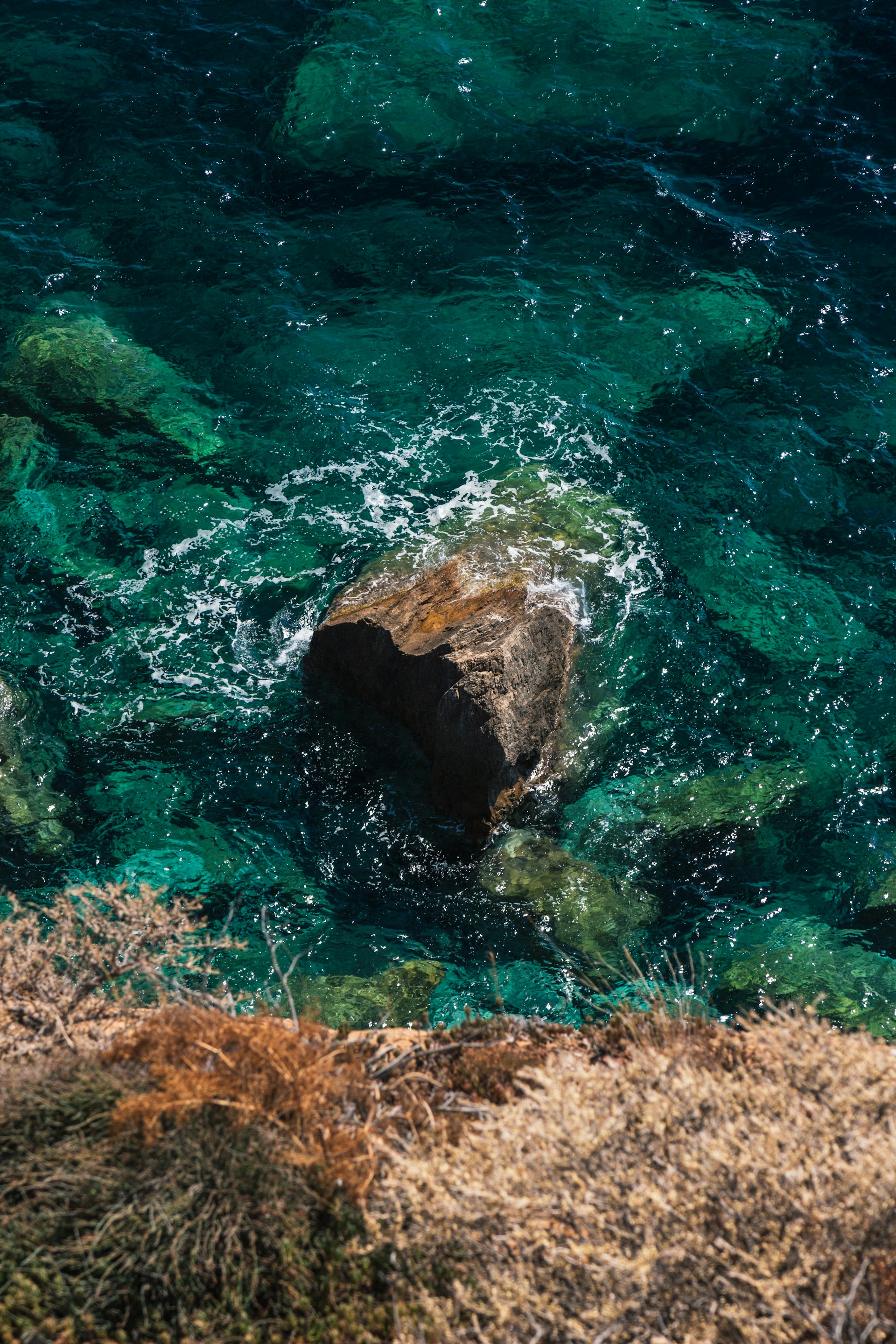 a large rock in the middle of a body of water