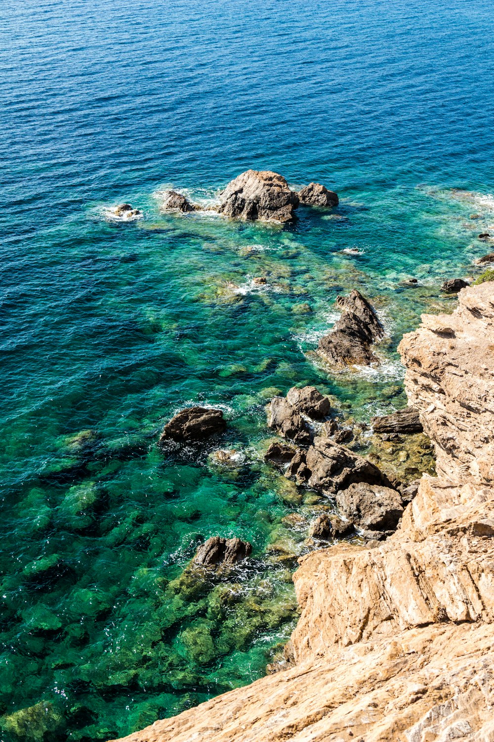 a body of water sitting next to a rocky shore