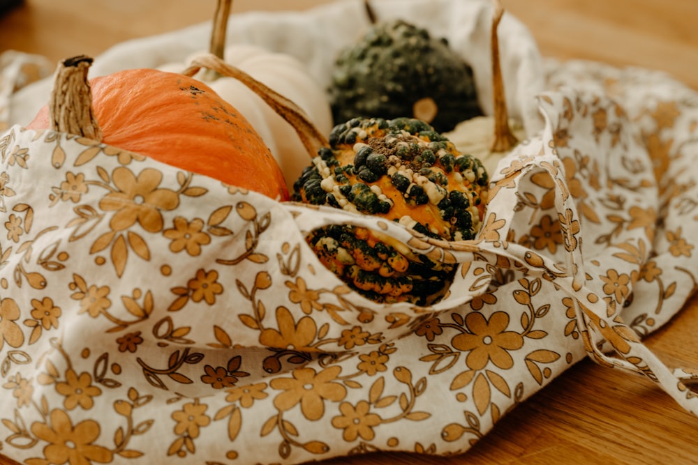 a cloth bag filled with pumpkins on top of a wooden table