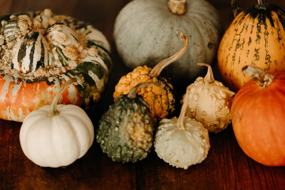 a group of pumpkins sitting on top of a wooden table