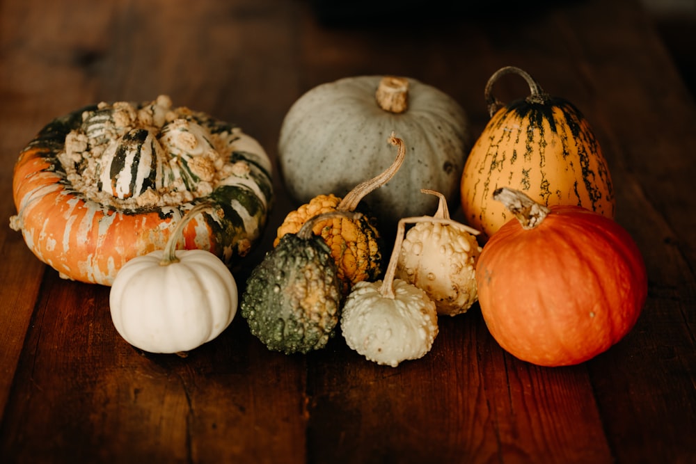a group of pumpkins sitting on top of a wooden table