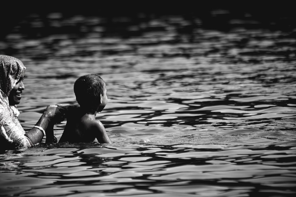 물 속에서 여자와 아이의 흑백 사진