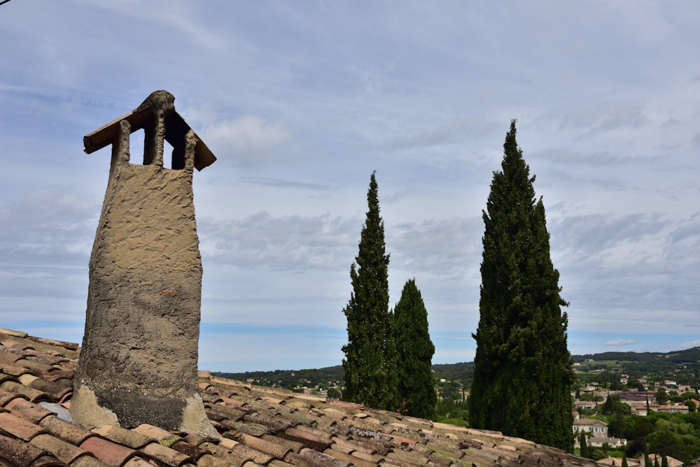 a bell tower on top of a roof with trees in the background