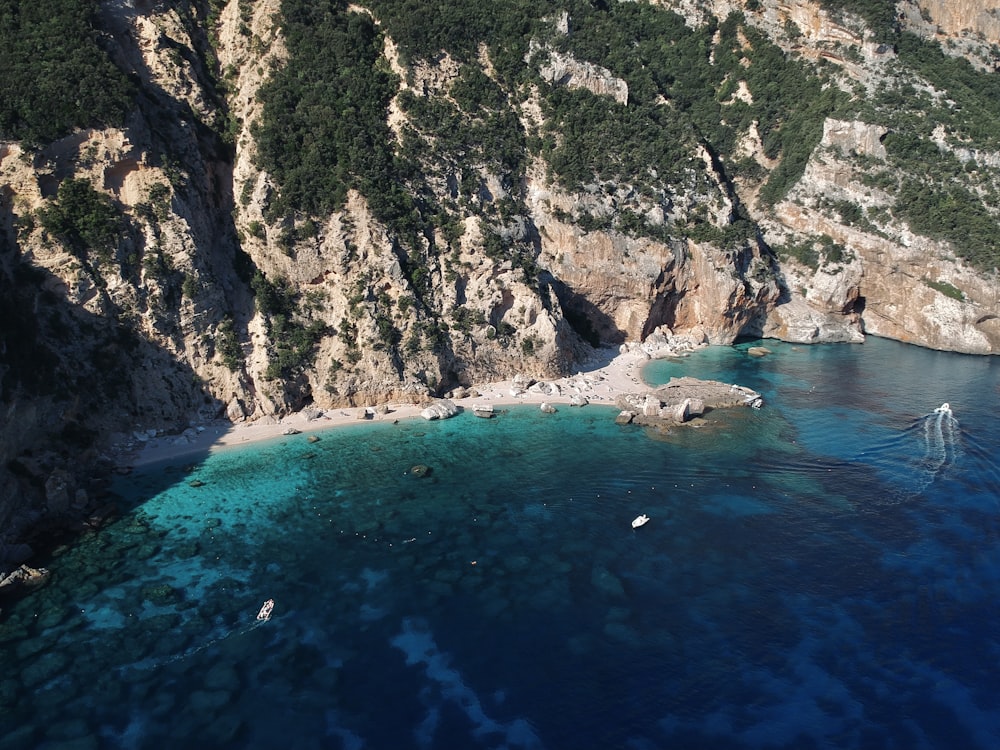 an aerial view of a beach with a boat in the water