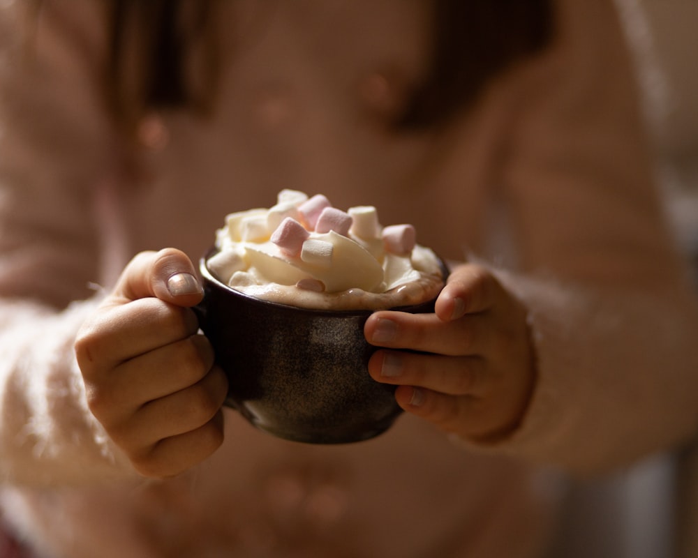 a person holding a bowl of food in their hands