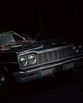 A vintage car with polished chrome details set against a black backdrop.