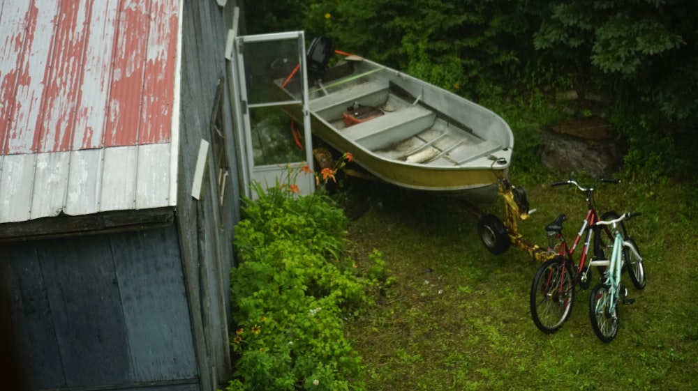 a bike parked next to a boat on the grass