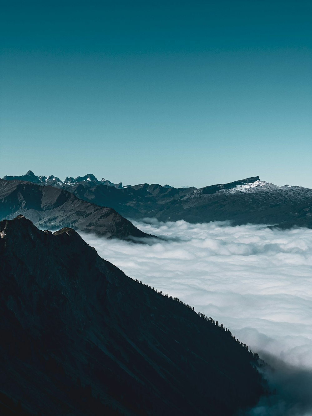 a view of the top of a mountain covered in clouds