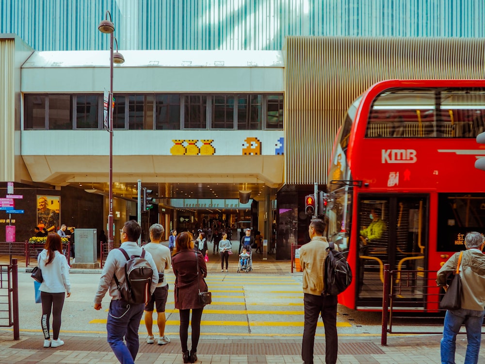 a red double decker bus driving down a street