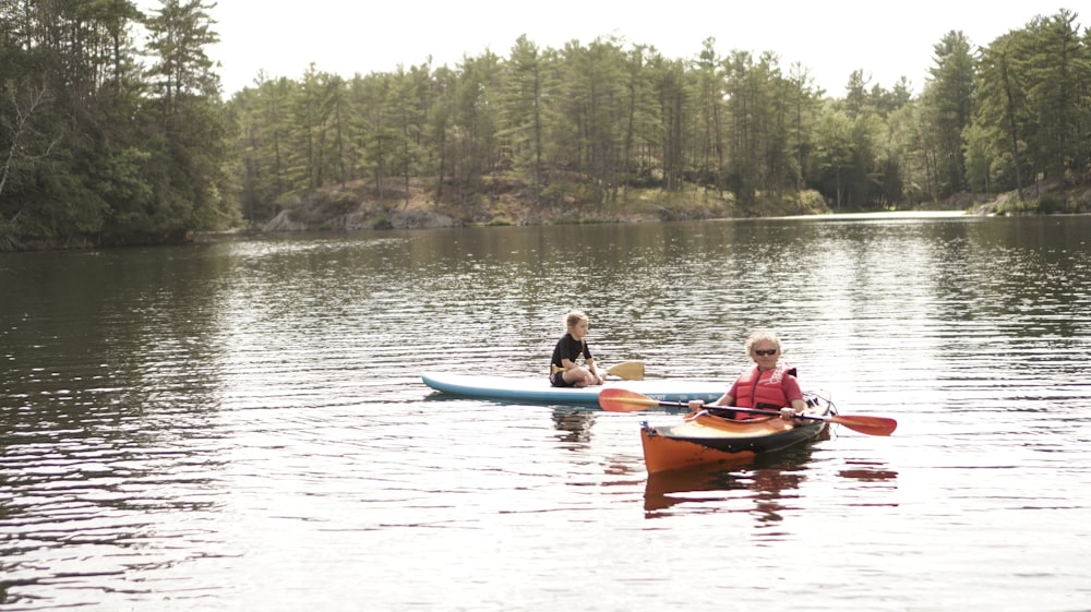 two people in canoes paddling on a lake