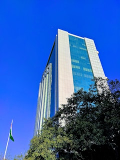 A modern office building in Bujumbura with the Burundi flag waving nearby under a clear blue sky.