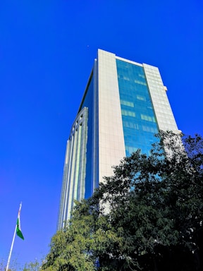 A modern office building in Bujumbura with the Burundi flag waving nearby under a clear blue sky.