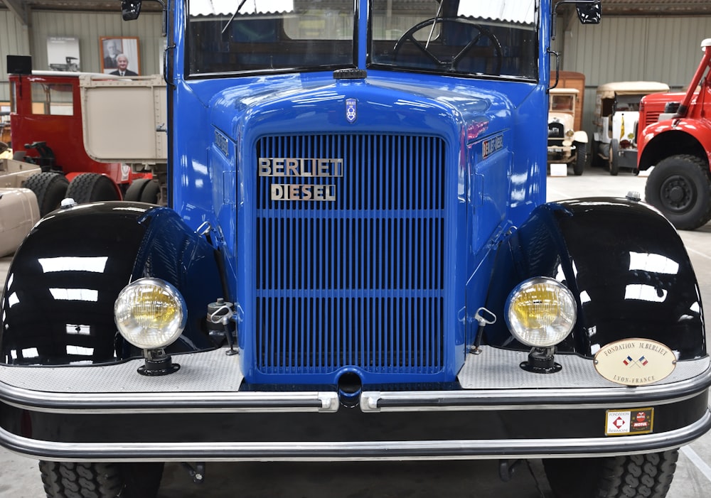 a blue truck parked in a garage next to other trucks