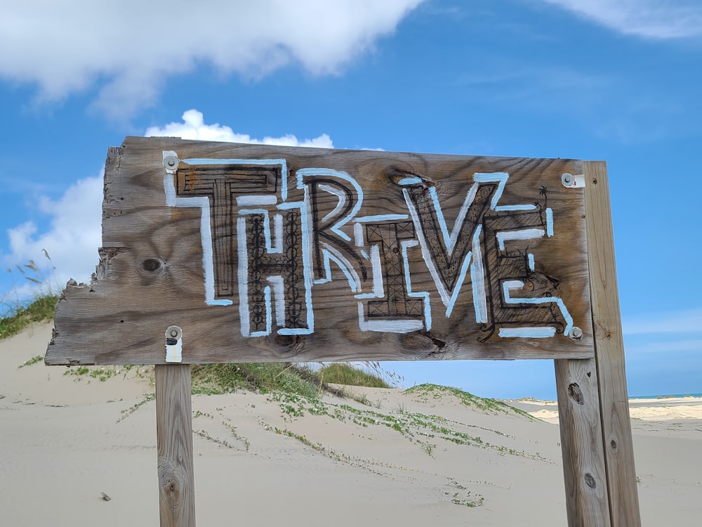 Un letrero de madera en una playa con la palabra valiente escrita en él