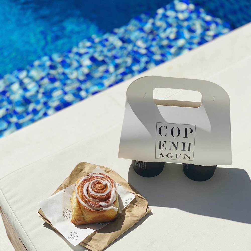 a pastry sitting on top of a piece of paper next to a pool