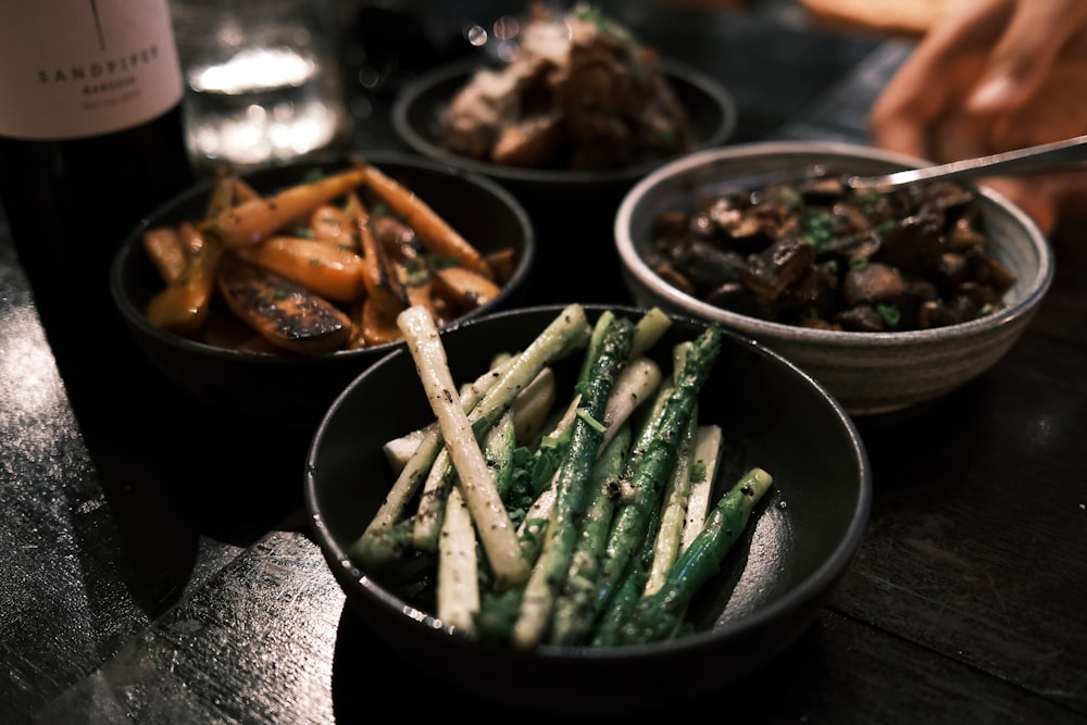 a close up of three bowls of food on a table