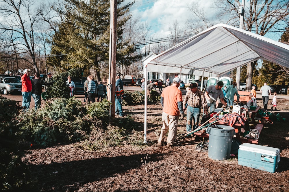 a group of people standing under a white tent