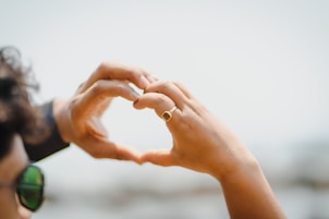 a woman making a heart shape with her hands