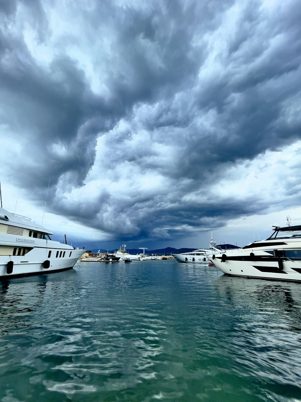 a body of water with boats in it under a cloudy sky