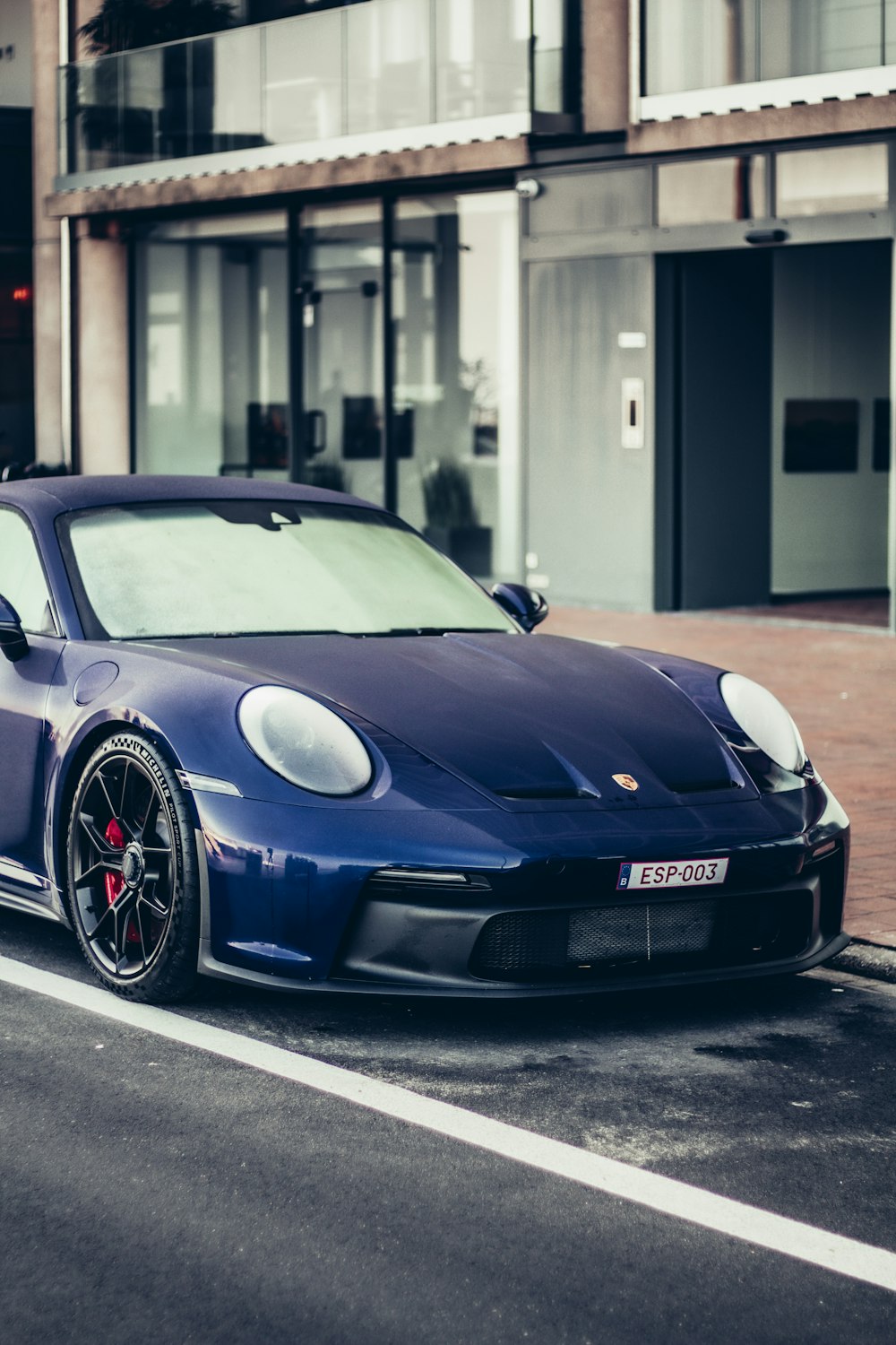 a blue sports car parked on the side of the road