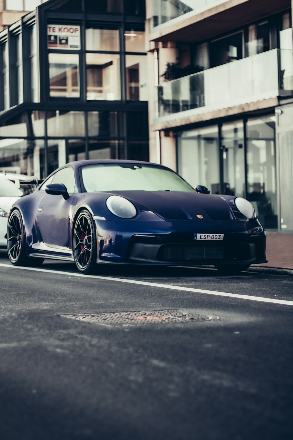 a blue sports car parked on the side of the road