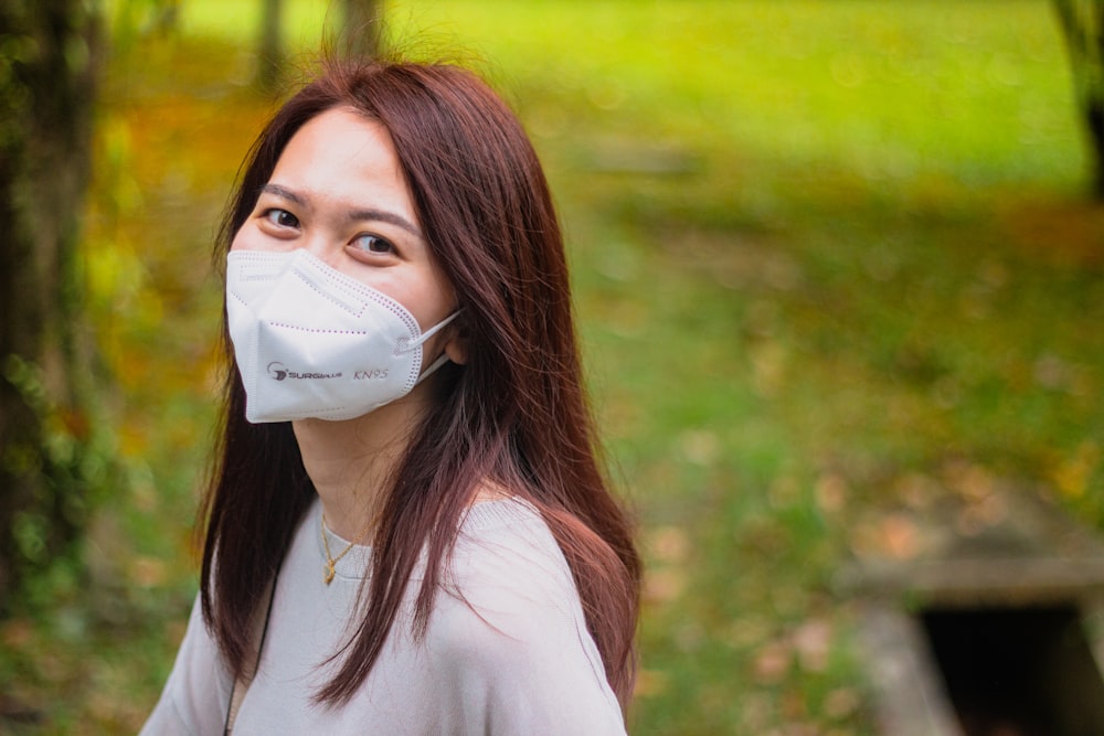 a woman wearing a face mask in a park