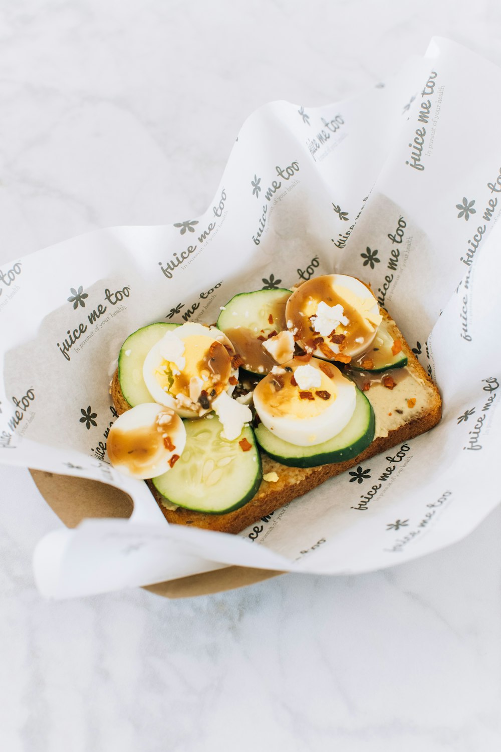 a piece of bread with cucumbers and other toppings