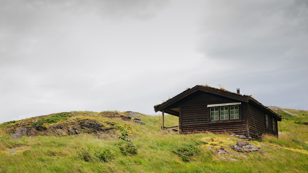 a small cabin sitting on top of a lush green hillside