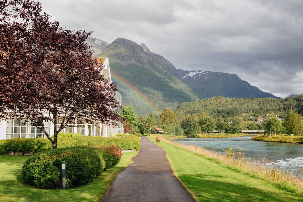 a rainbow in the sky over a river and a house