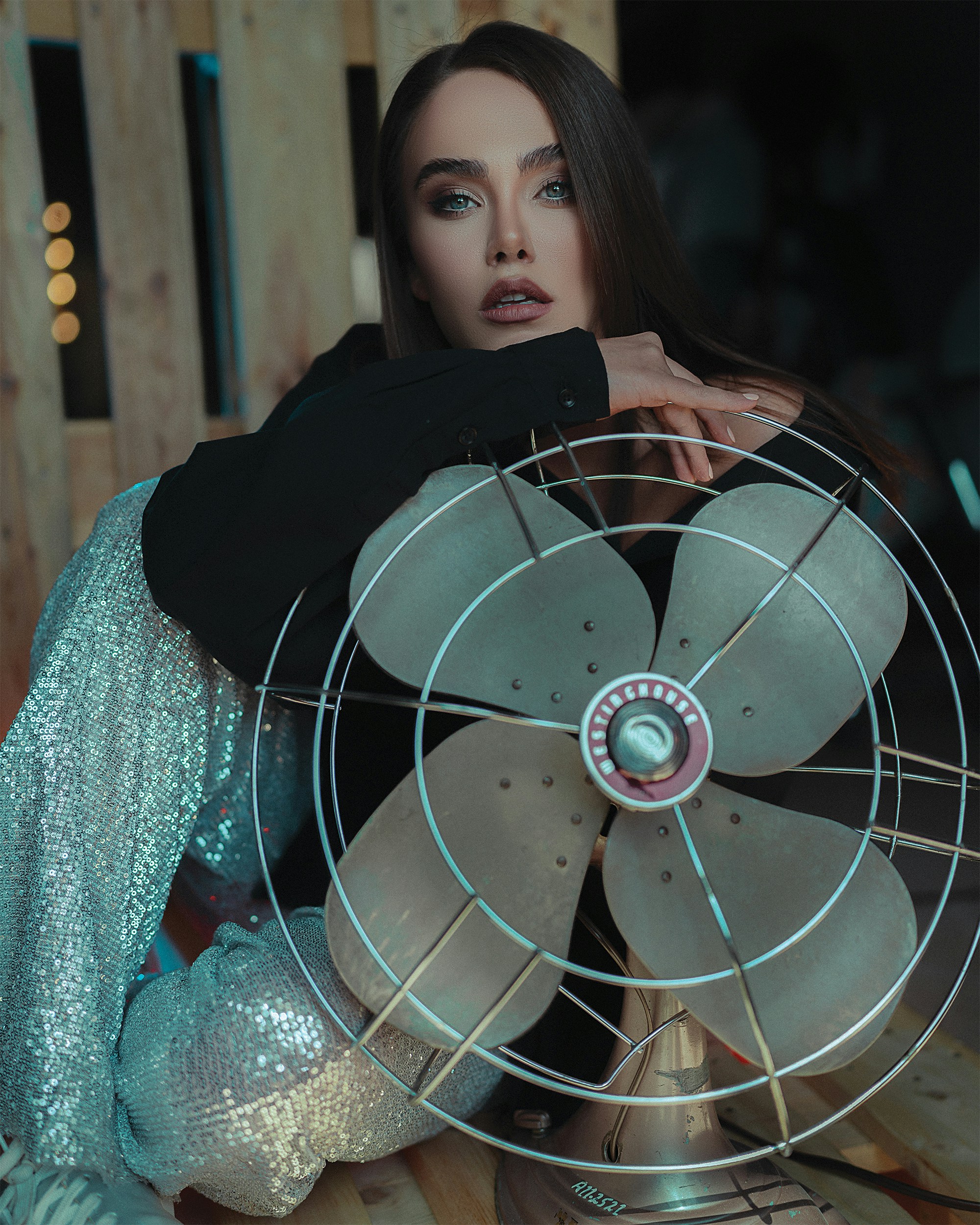 a woman sitting on a table holding a fan