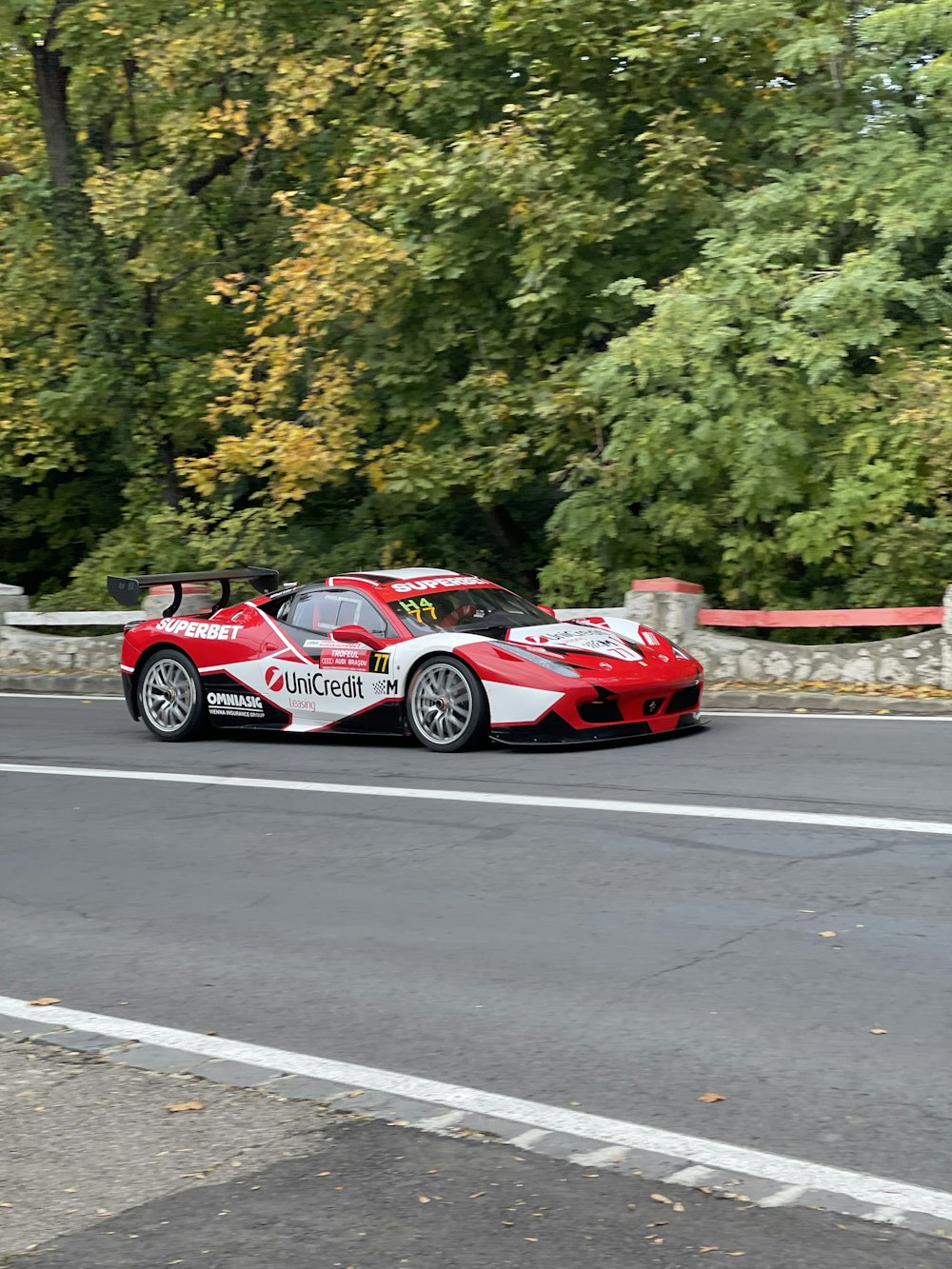 a red and white race car driving down a road