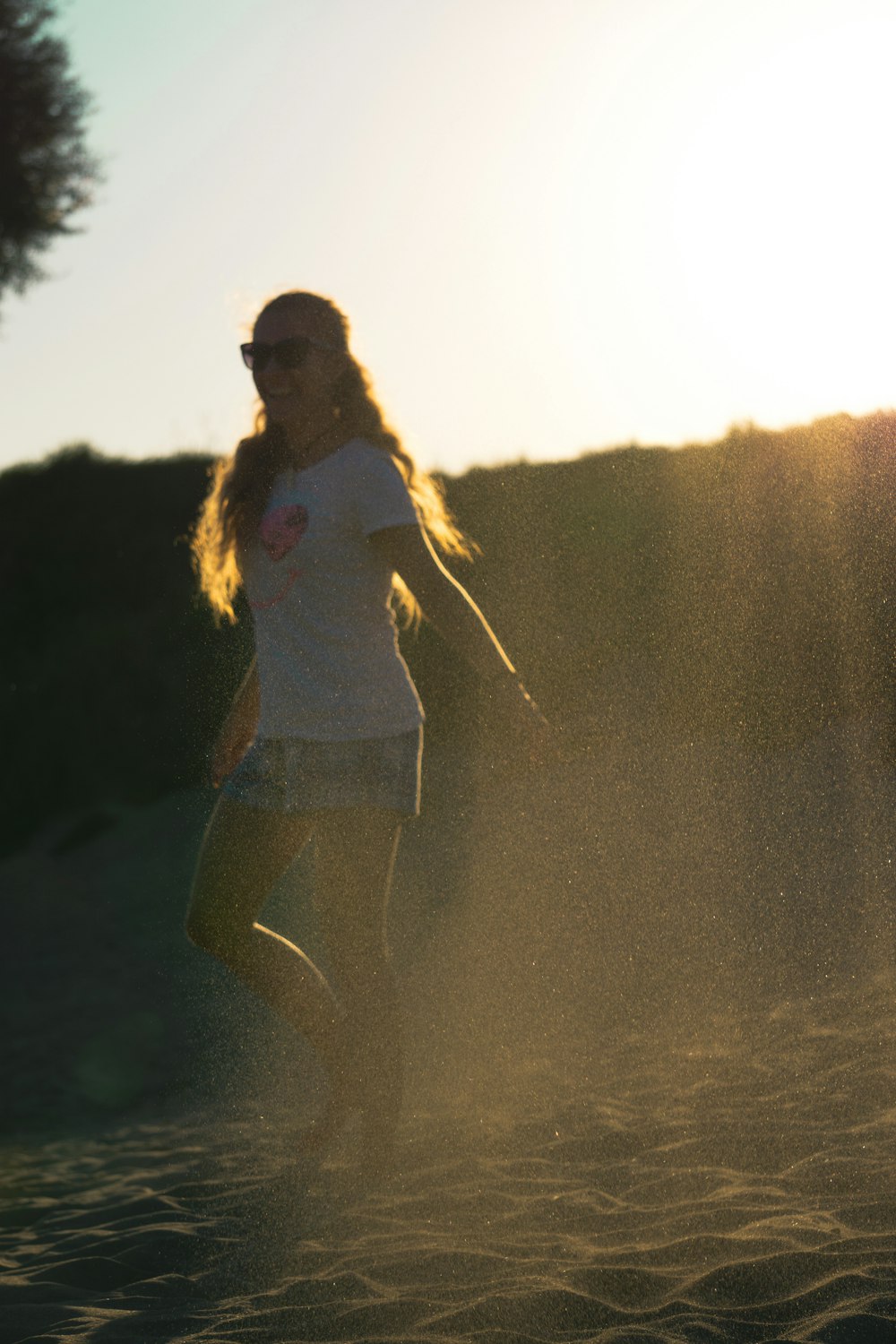 a woman in a white shirt and shorts playing with a frisbee