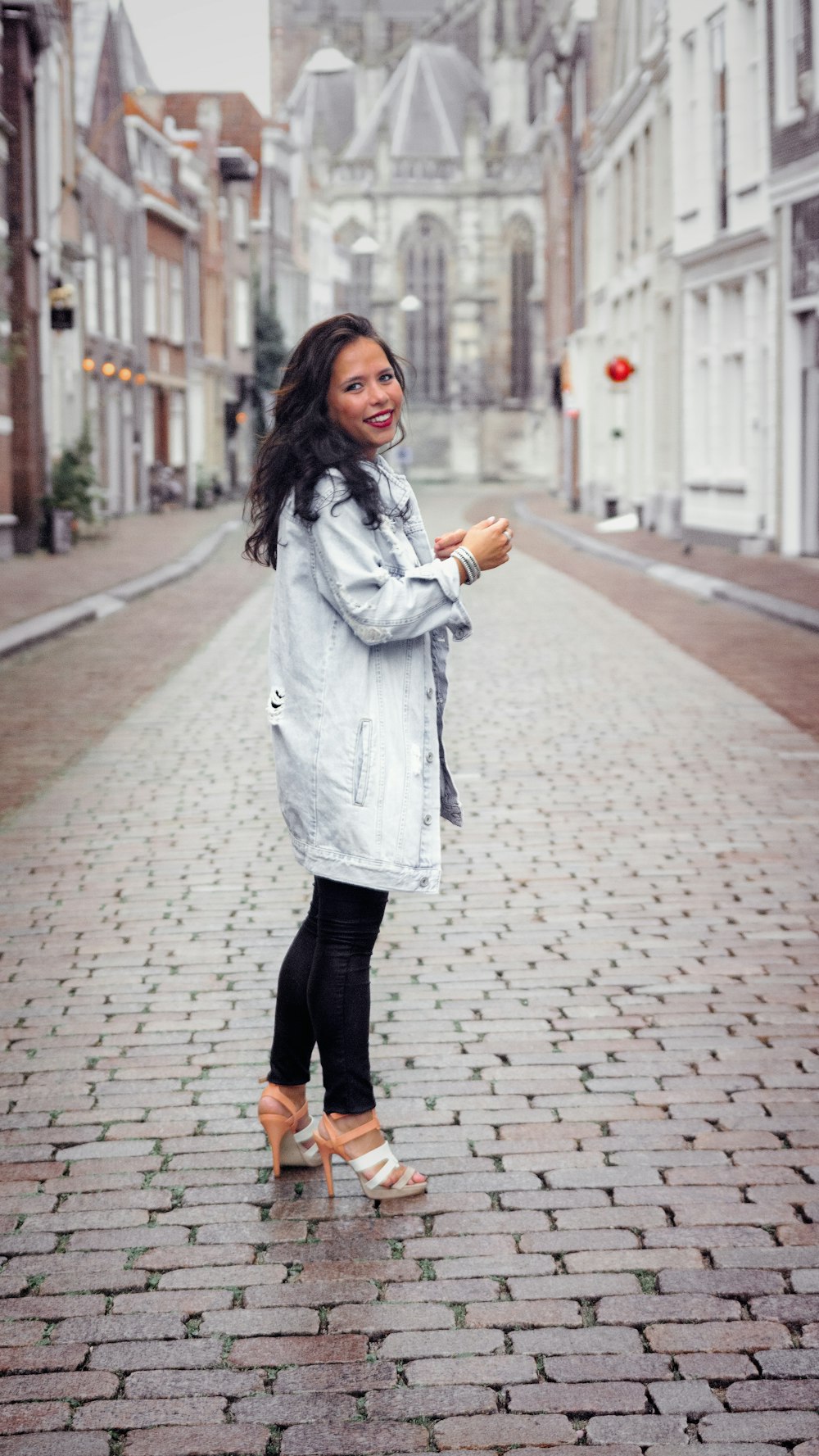 a woman standing in the middle of a brick road