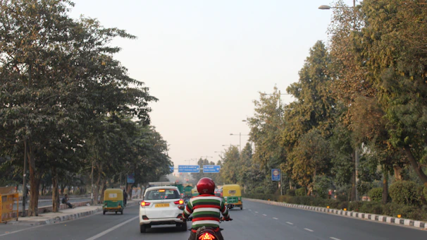 A learner confidently riding a motorcycle on a quiet Bengaluru street during training.