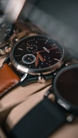 A close-up view of a sophisticated wristwatch with a black dial and a brown leather strap. The watch features intricate details, including multiple sub-dials and silver accents. The focus is on the craftsmanship and elegance of the timepiece.
